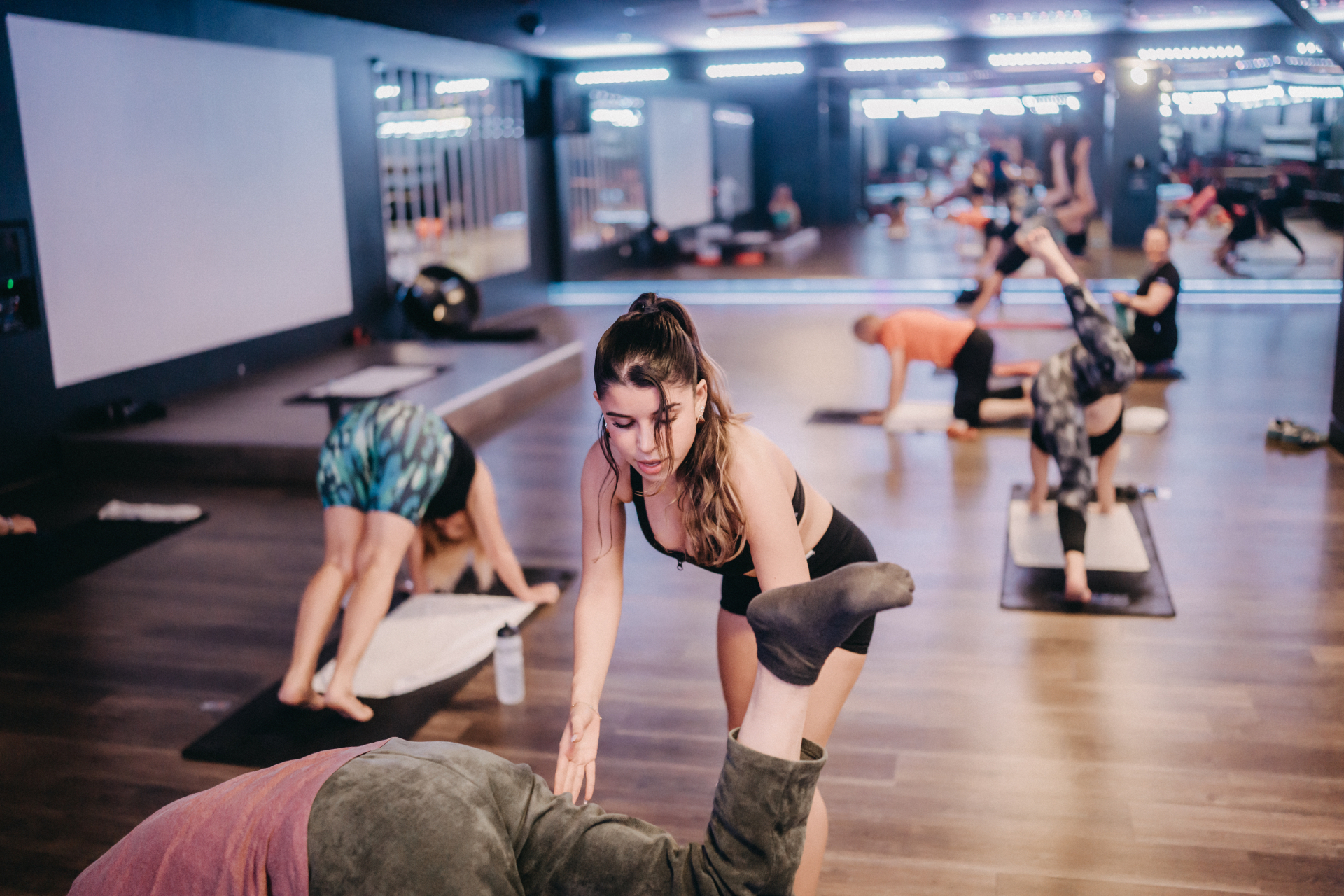 Hands-on pilates adjustment during a studio class