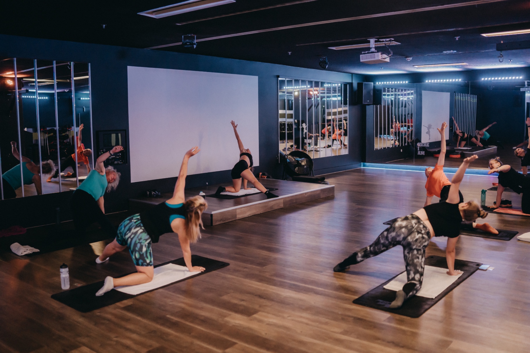 Evening pilates class with mirrored studio reflections