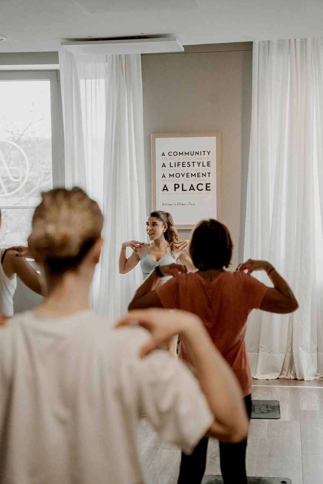 Shideh leading a pilates class in a bright studio